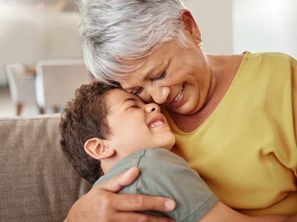 older woman in yellow top hugging boy