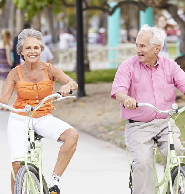 man and woman riding bikes on busy pathway