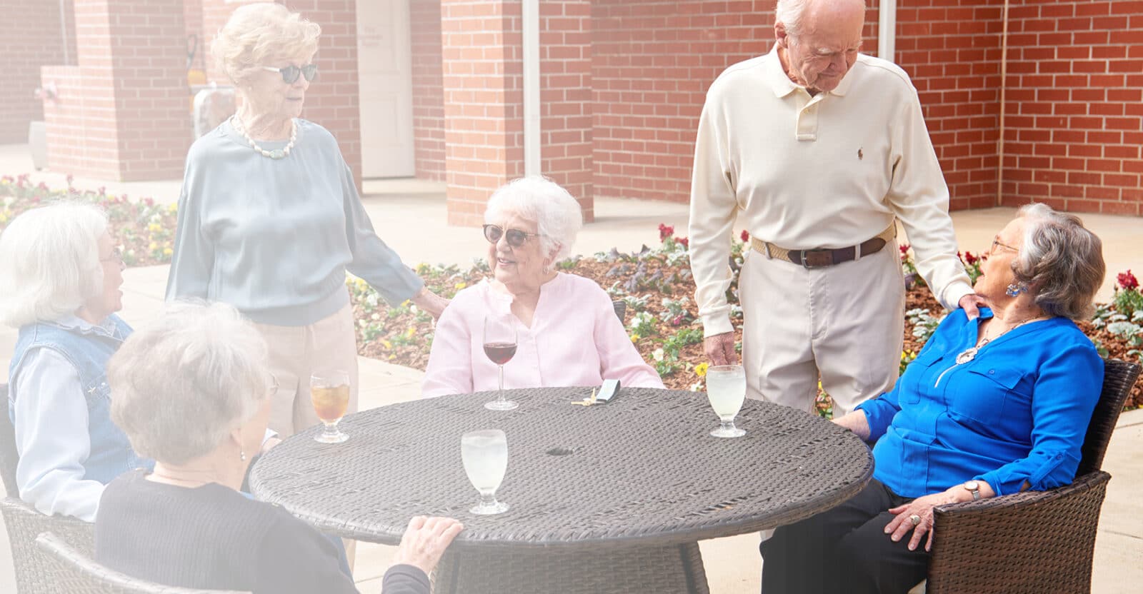 friends chatting at an outside table while enjoying drinks